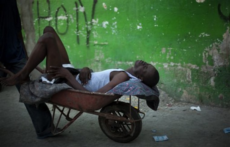 A young man suffering cholera symptoms is pushed in a wheelbarrow to St. Catherine hospital, run by Doctors Without Borders, in the Cite Soleil slum in Port-au-Prince, Haiti, on Friday.
